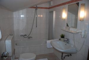 ein Badezimmer mit einer Badewanne, einem Waschbecken und einem WC in der Unterkunft Landhaus Brieger in Henndorf am Wallersee