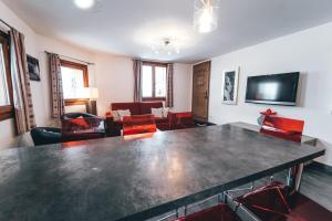 sala de estar con mesa grande y sillas rojas en Appartement Orion by ExplorHome, en Tignes