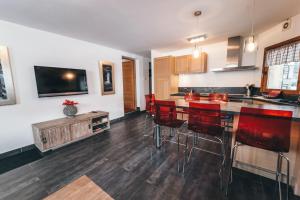 una cocina con una barra con sillas rojas. en Appartement Orion by ExplorHome, en Tignes