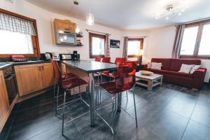 a kitchen and living room with a table and chairs at Appartement Orion by ExplorHome in Tignes +5 photos