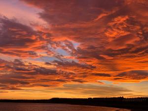 um pôr-do-sol sobre um corpo de água em The queens head em Newbiggin-by-the-Sea