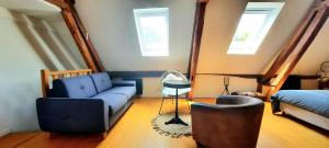 een woonkamer met een blauwe bank en een bed bij Loft de charme á 150m de la cathédrale in Beauvais