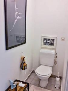 a bathroom with a toilet and a picture on the wall at Lovely Appart near Paris, 15 mins to Opéra, Galerie Lafayette, Louvre in Levallois-Perret
