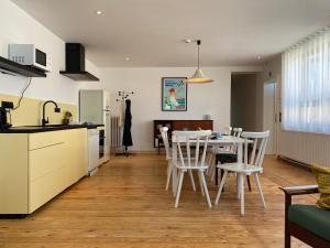 Una cocina y un comedor con mesa y sillas. en Family Floor - La Couronne Oostende - Authentiek appartement met veel lichtinval, en Ostende 22 fotos más