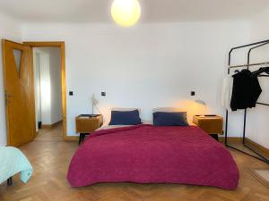 Un dormitorio con una cama grande con una manta morada. en Family Floor - La Couronne Oostende - Authentiek appartement met veel lichtinval, en Ostende