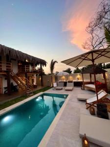 a swimming pool with lounge chairs and an umbrella at Casa Bali Vichayito in Vichayito