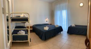 a small room with two beds and a ladder at Hotel Marylise in Rimini