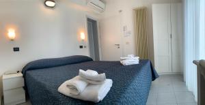 a room with a bed with towels on it at Hotel Marylise in Rimini