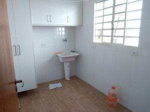 een witte badkamer met een wastafel en een raam bij Casa MAGNÍFICA a 1 Km do centrinho com Suíte e Hidro in Camanducaia