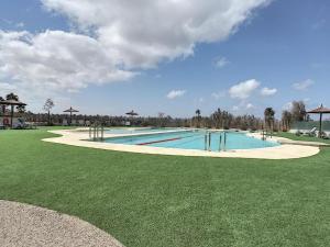 a large swimming pool in a park with a grass field at 'Dreamy sunsets' - appartement met 3 slaapkamers in Playa Honda