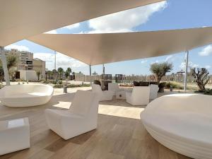 a patio with white chairs and a large umbrella at 'Dreamy sunsets' - appartement met 3 slaapkamers in Playa Honda