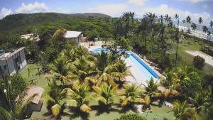 an aerial view of a resort with a pool and palm trees at Ilhéus North Residence Danilo in Uruçuca