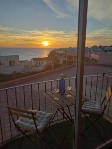 una mesa y sillas en un balcón con vistas al océano en Jandia Beach, en Morro del Jable