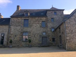 - un grand bâtiment en briques avec une porte et des fenêtres dans l'établissement Chambre indépendante au Manoir de la Célinais côté jardin, à Saint-Aubin-du-Cormier