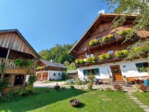 ein großes Holzgebäude mit Pflanzen auf den Balkonen in der Unterkunft Haus Annerl in Grundlsee