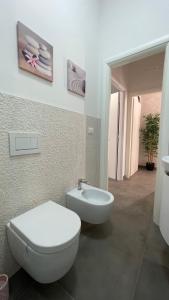 ein Badezimmer mit einem weißen WC und einem Waschbecken in der Unterkunft GUEST HOUSE KINGA CAVOUR in Florenz