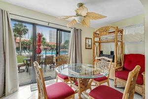 ein Wohnzimmer mit einem Glastisch und Stühlen in der Unterkunft Gulf Highlands - 149 Grand Island in Panama City Beach