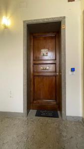 a large wooden door in a room with a wall at GUEST HOUSE KINGA CAVOUR in Florence