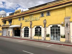 a yellow building on the side of a street at Hotel Inn Galerias in Aguascalientes