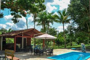 a patio with a table and chairs and a pool at Chácara Maluco Beleza 1 in Chã Grande