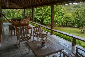 a screened in porch with a table and chairs at Chácara Maluco Beleza 1 in Chã Grande