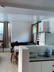 a kitchen with white cabinets and a table in a room at Casa Ribeirao da Ilha in Florianópolis
