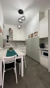 una cucina con tavolo bianco e armadietti bianchi di GUEST HOUSE KINGA CAVOUR a Firenze
