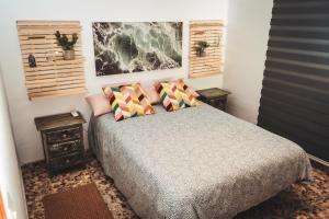 Chalet Novo Sancti Petri Surf House في شيكلانا دي لا فرونتيرا: غرفة نوم عليها سرير ووسادتين