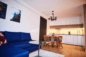 a living room with a blue couch and a table at Olivia Baltic in Gdańsk