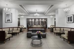uma sala de espera com sofás, mesas e lustres em The Manhattan at Times Square em Nova Iorque