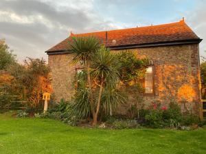 a brick house with a palm tree in front of it at Old Chapel Forge in Chichester