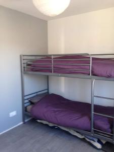 Zimmer mit 3 Etagenbetten mit lila Bettwäsche in der Unterkunft Escapade a Chaucre - St Georges - Maison plain pied - 3 chambres - 7 couchages in Chaucre