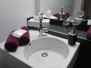 a bathroom sink with purple towels on it at Rhodaer Grund in Erfurt