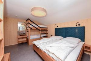 a bedroom with a large bed and bunk beds at Haller´s Posthaus in Riezlern