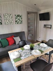 ein Wohnzimmer mit einem Tisch und einem Sofa in der Unterkunft domki przy lipowej 16 in Łuka