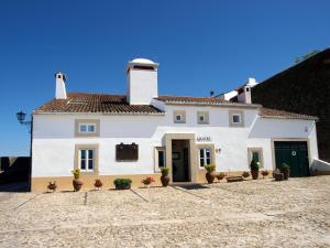 a white house with potted plants in front of it at El-Rei Dom Manuel Hotel in Marvão