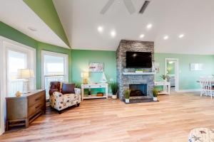 a living room with a fireplace and a tv at Life's a Beach in Dauphin Island