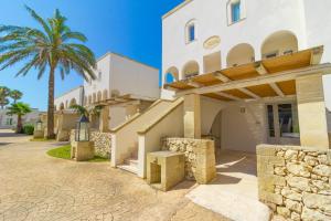 a building with a palm tree in front of it at HOTEL BARONE DI MARE in Torre dell'Orso