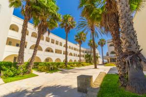 a row of palm trees in front of a building at HOTEL BARONE DI MARE in Torre dell'Orso