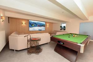 a living room with a pool table and couch at Haller´s Posthaus in Riezlern