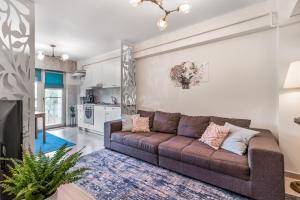 uma sala de estar com um sofá e uma cozinha em DreamGarden Airport apartment & Secure parking & Airport shuttle em Iaşi