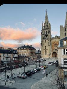 a city with cars parked in front of a church at Gîte de Mende in Mende