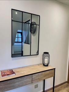 einen Spiegel an einer Wand über einem Holztisch in der Unterkunft Gîte de Mende in Mende