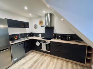 una cocina con electrodomésticos en blanco y negro y una escalera en Gîte de Mende en Mende