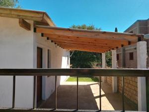 a wooden pergola on the side of a building at Chalet Los Molles in Villa Giardino