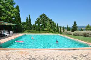 two people are swimming in a swimming pool at Campocane Oaks in Trevinano