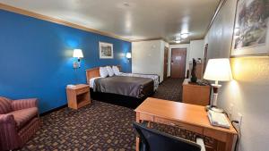 een kleine hotelkamer met een bed en een bureau bij Velkommen Inn in Clifton