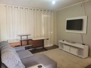 a living room with a couch and a flat screen tv at Raio de Luz in Piranhas