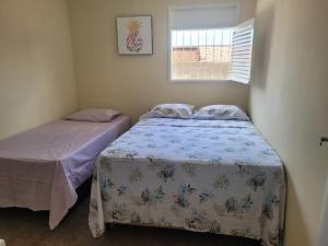 a bedroom with two beds and a window at Raio de Luz in Piranhas