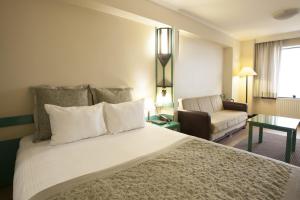 ein Hotelzimmer mit einem großen Bett und einem Sofa in der Unterkunft Kadıköy Rıhtım Hotel in Istanbul